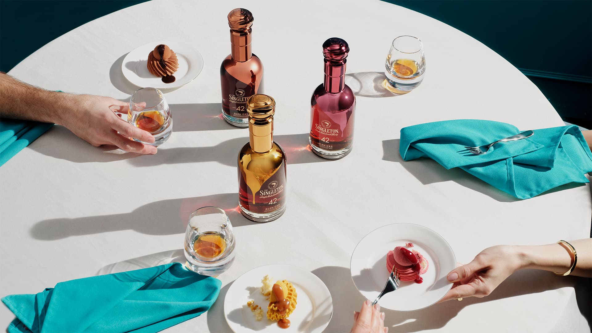 Three people eating three desserts on a table that pairs with The Singleton Gourmand Collection