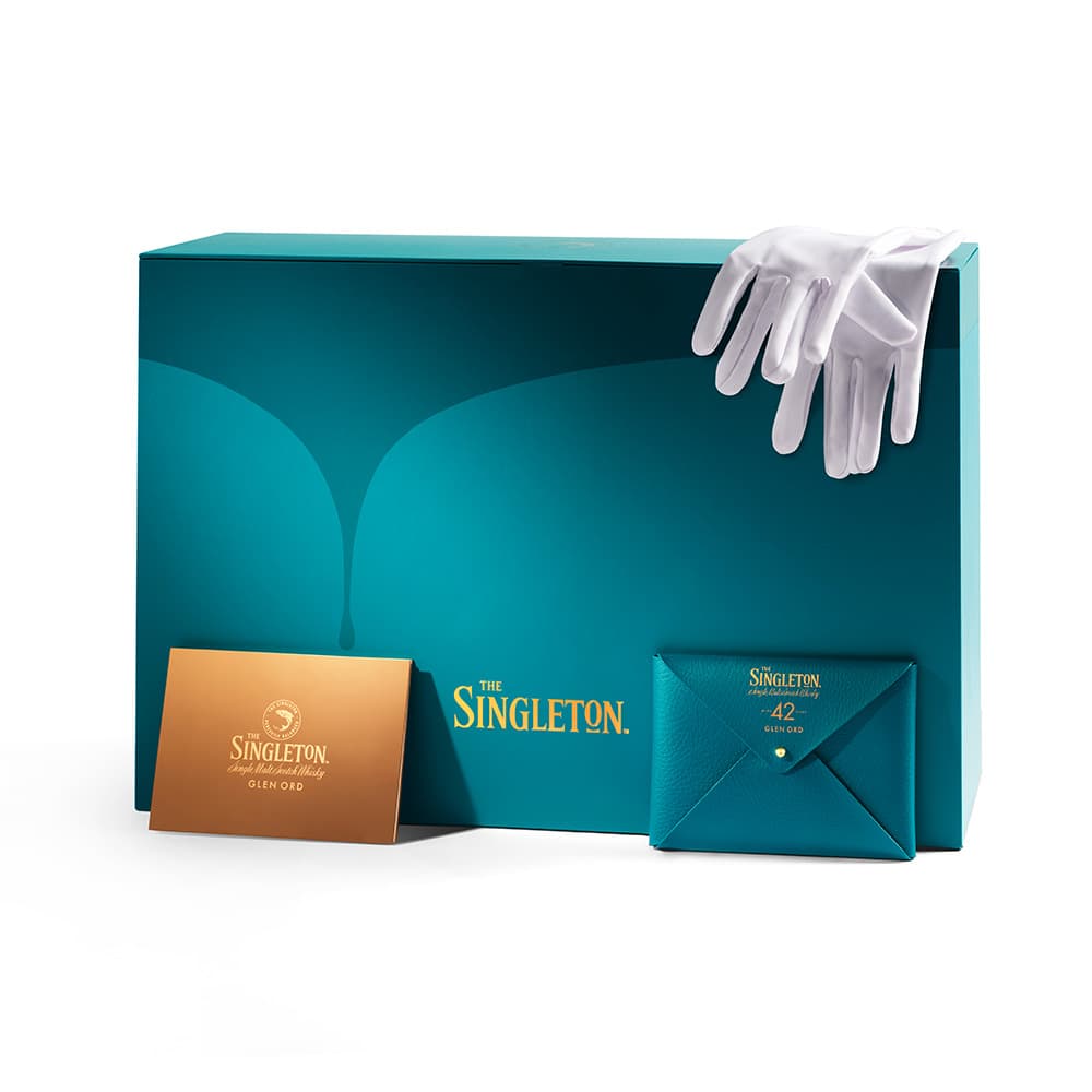 The Singleton Gourmand Collection packaging with a gold card and white gloves