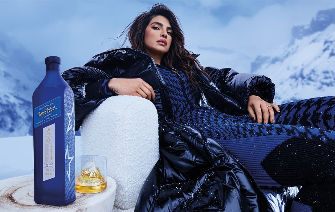 Priyanka Chopra Jonas sitting with Johnnie Walker Blue Label Ice Chalet beside her with a glass half full